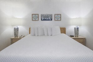 A neatly made bed with white bedding, flanked by two bedside tables with lamps, and two wall-mounted signs with motivational quotes. - Phoenix Iii 3013 1 Bedroom Condo (Orange Beach)
