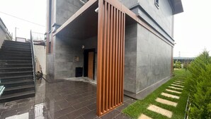 A modern building with a large entrance, a staircase, and a well-maintained garden area. - 4-bedroom house in lovely İstanbul with forest view.Nearest Istanbul Airport. (Bolluca)