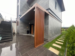 A modern building with a large entrance, a staircase, and a well-maintained garden area. - 4-bedroom house in lovely İstanbul with forest view.Nearest Istanbul Airport. (Bolluca)