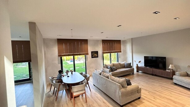 A spacious living room with a dining table, sofas, a TV, and large windows. - 4-bedroom house in lovely İstanbul with forest view.Nearest Istanbul Airport. (Bolluca)