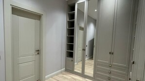 A room with a grey door, a mirrored wardrobe, and a wooden floor. - 4-bedroom house in lovely İstanbul with forest view.Nearest Istanbul Airport. (Bolluca)