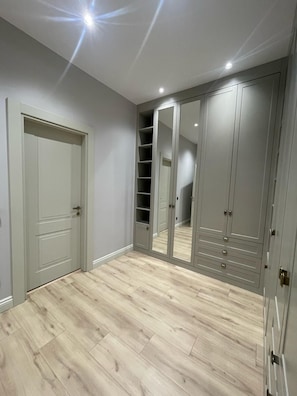 A room with a grey door, a mirrored wardrobe, and a wooden floor. - 4-bedroom house in lovely İstanbul with forest view.Nearest Istanbul Airport. (Bolluca)