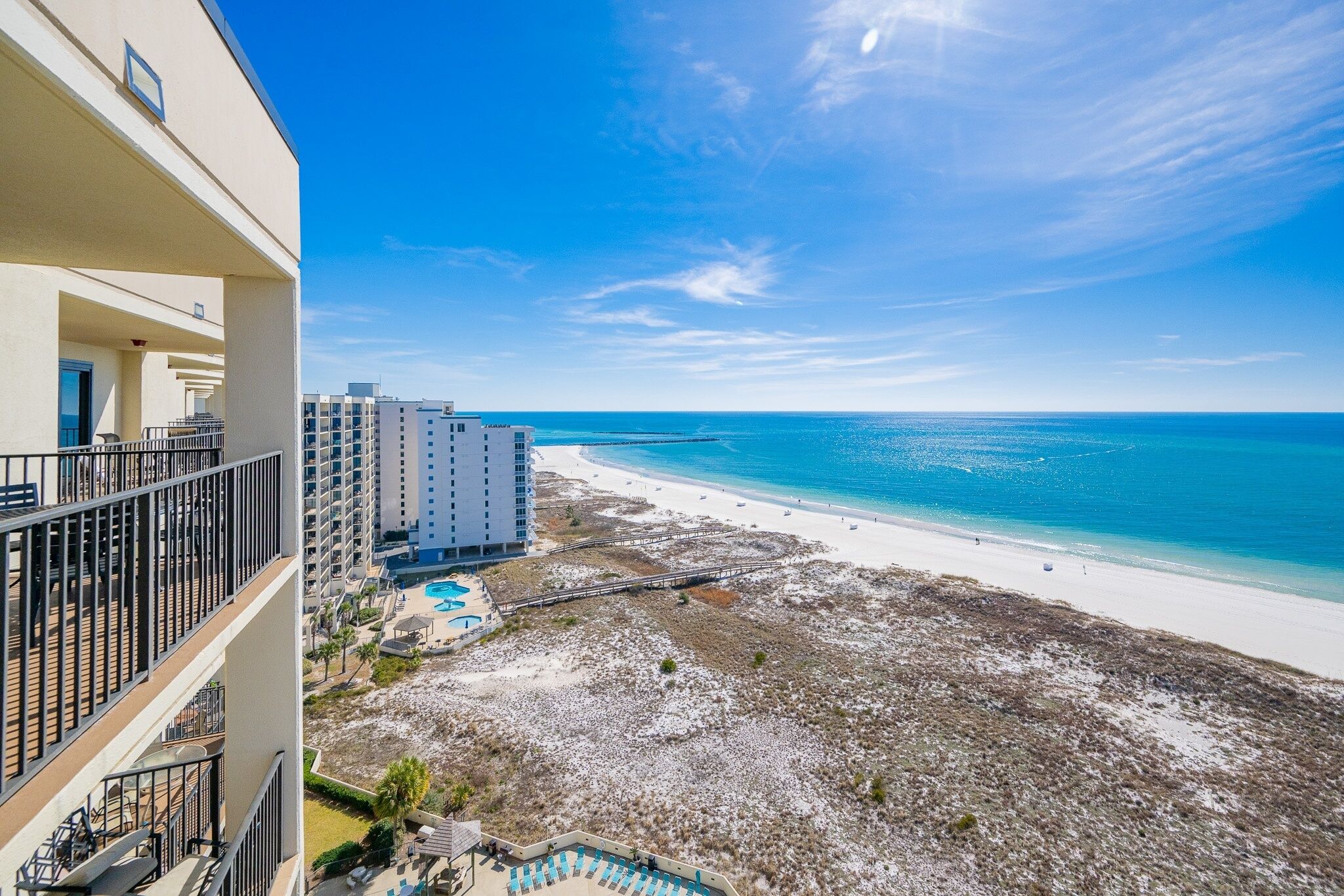 A beachfront hotel with a pool, beach access, and a clear view of the ocean.