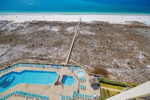 An aerial view of a resort with a swimming pool, beach, and a long pier. - Phoenix Vii 71506 2 Bedroom Condo (Orange Beach)