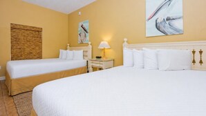 A hotel room with two beds, a bedside table with a lamp, and artwork on the walls. - Phoenix Vii 7012 3 Bedroom Condo (Orange Beach)