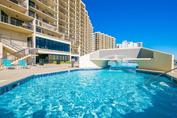Une piscine avec un bâtiment moderne en arrière-plan.