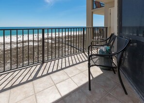 Un balcon avec vue sur une plage et l’océan.