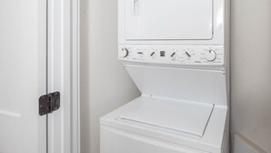 A white wall-mounted washer and dryer unit with control knobs and a door. - Phoenix Vii 7813 2 Bedroom Condo (Orange Beach)