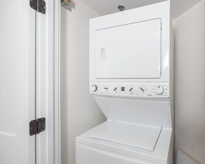 A white wall-mounted washer and dryer unit with control knobs and a door. - Phoenix Vii 7813 2 Bedroom Condo (Orange Beach)