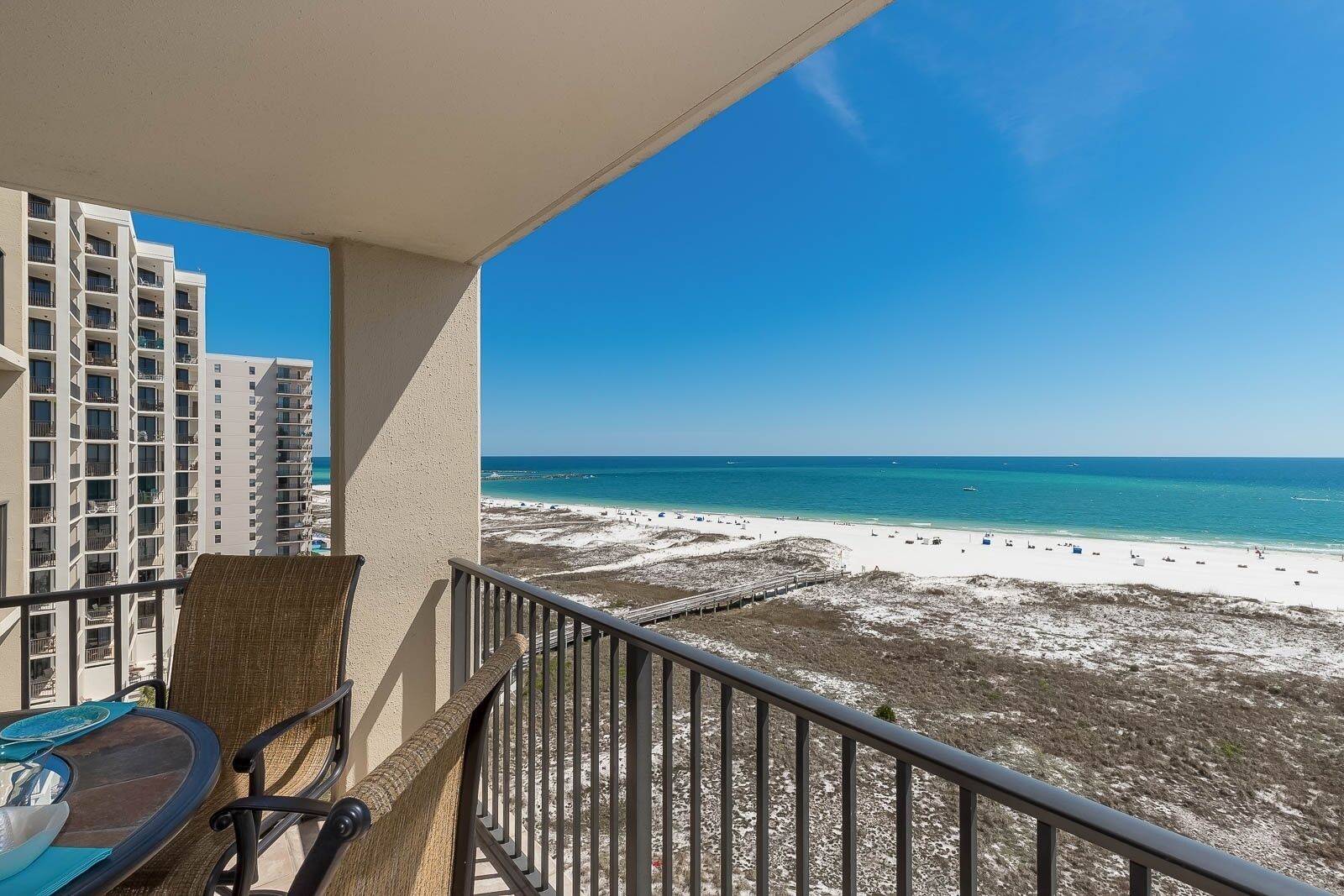 A balcony with a view of a beach and high-rise buildings.