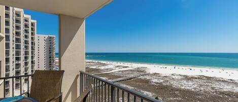 A balcony with a view of a beach and high-rise buildings.