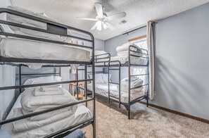 A room with bunk beds, a ceiling fan, and a window. - Near Dining & MEM - Hickory Hill Home (Memphis)