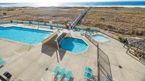 A pool area with multiple pools, sun loungers, and a view of the beach. - Phoenix Vii 7306 2 Bedroom Condo (Orange Beach)