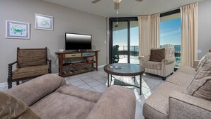 A living room with a television, a wooden coffee table, and two sofas. - Phoenix Vii 7306 2 Bedroom Condo (Orange Beach)