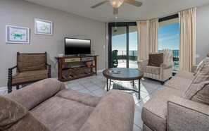 Ein Wohnzimmer mit Fernseher, einem Holztisch und zwei Sofas.