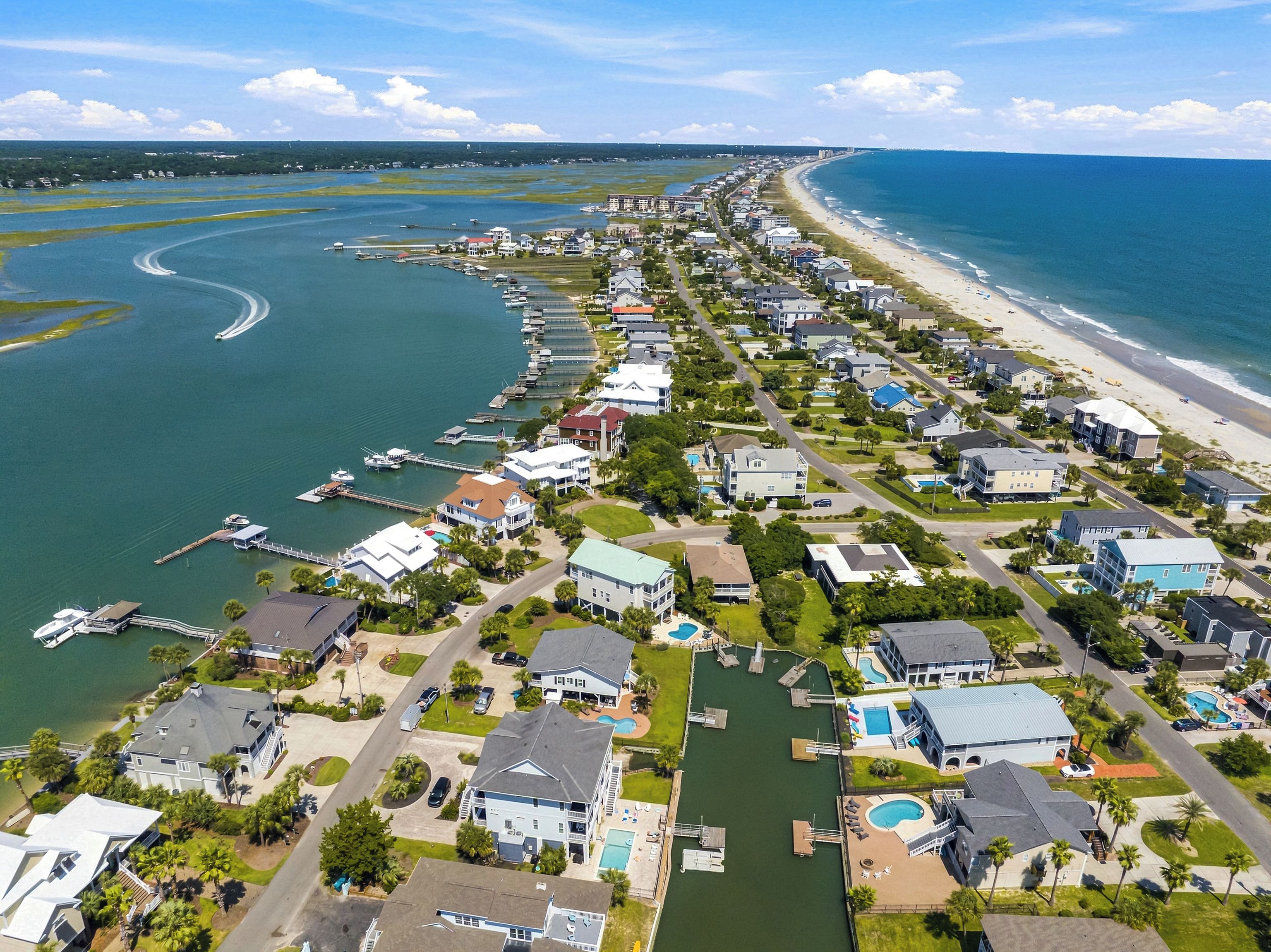Zona residencial costera con casas, una playa y un puerto deportivo.