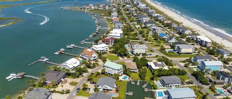 Zona residencial costera con casas, una playa y un puerto deportivo.