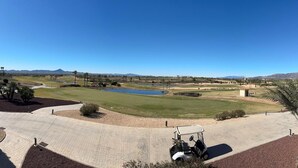 A golf course with a pond, palm trees, and distant mountains. - Apartment 'Soleil' with Shared Pool, Wi-Fi and Air Conditioning (Fuente Álamo de Murcia)