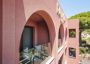 A pink building with a balcony, a window, and a sign that reads 'PALACE'.