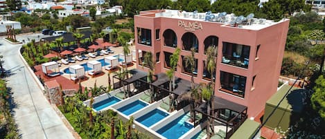 Un hôtel doté d’une piscine sur le toit, de plusieurs balcons et offrant une vue sur la mer.