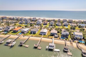 A coastal residential area with houses, a beach, and a marina with docks and boats. - Majestic Dream: Oceanfront, Pool, Hot Tub & Endless Coastal Days (Murrells Inlet)