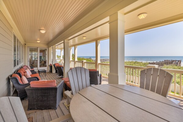 A covered outdoor seating area with a view of the ocean. - Majestic Dream: Oceanfront, Pool, Hot Tub & Endless Coastal Days (Murrells Inlet)