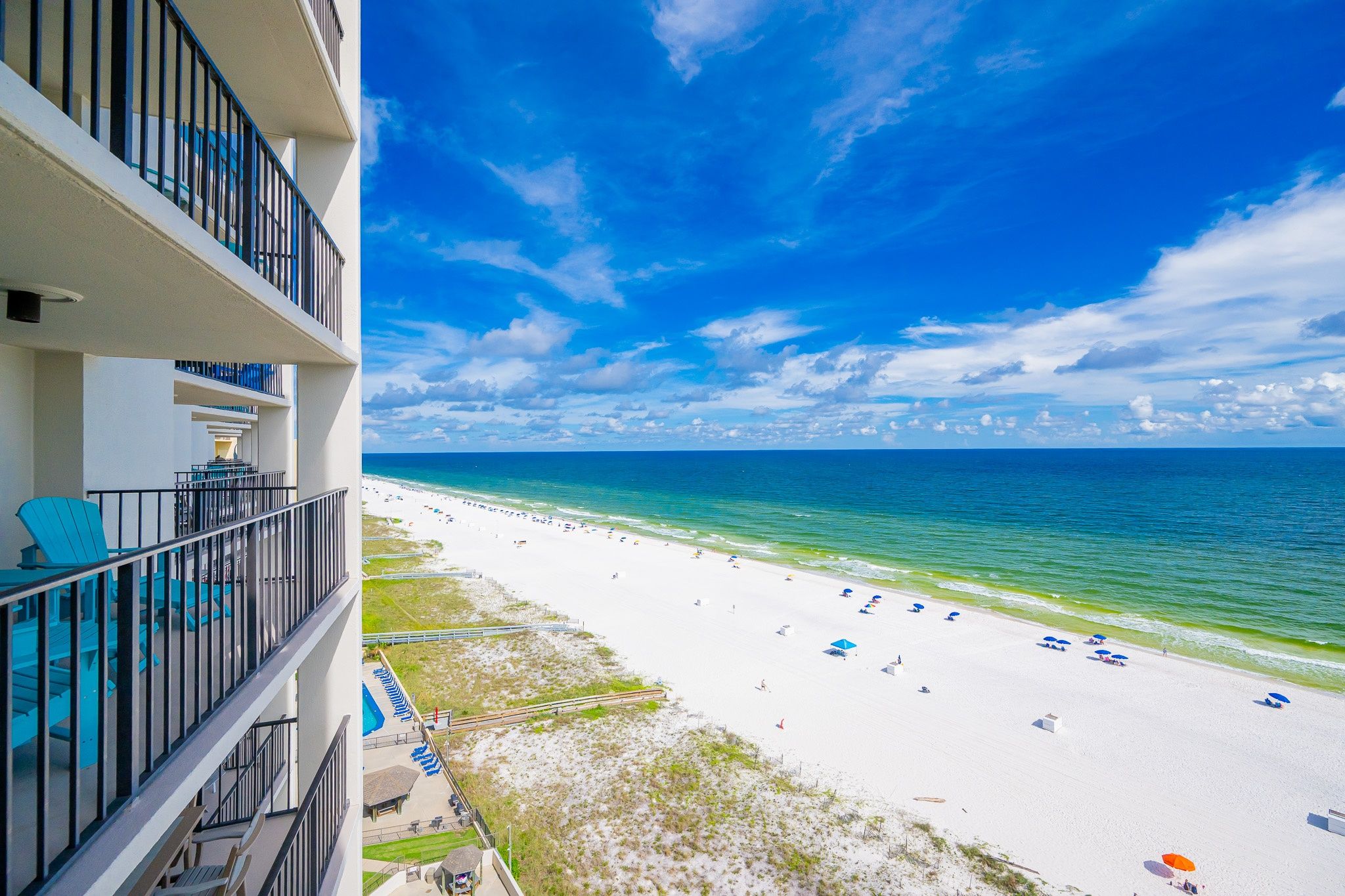 Ein Balkon eines Hotels direkt am Strand mit Blick auf den Sandstrand und das Meer.