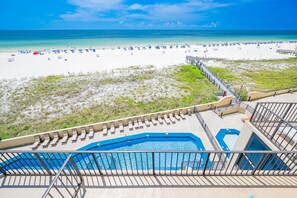 A beach view from a resort balcony with a pool and lounge chairs. - Phoenix Iii 3047 1 Bedroom Condo (Orange Beach)