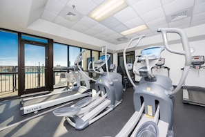 Ein Fitnessstudio mit Laufbändern, Crosstrainern und Rudergeräten.