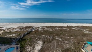 A beach with a wooden boardwalk leading to a pool area. - Phoenix Vii 7917 3 Bedroom Condo (Orange Beach)