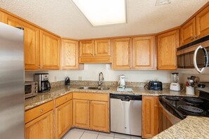 Eine Küche mit Holzschränken, einem Geschirrspüler, einer Mikrowelle, einer Kaffeemaschine und einem Toaster.