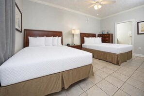 A hotel room with two beds, a ceiling fan, a nightstand, and a lamp. - Phoenix Vii 71215 2 Bedroom Condo (Orange Beach)