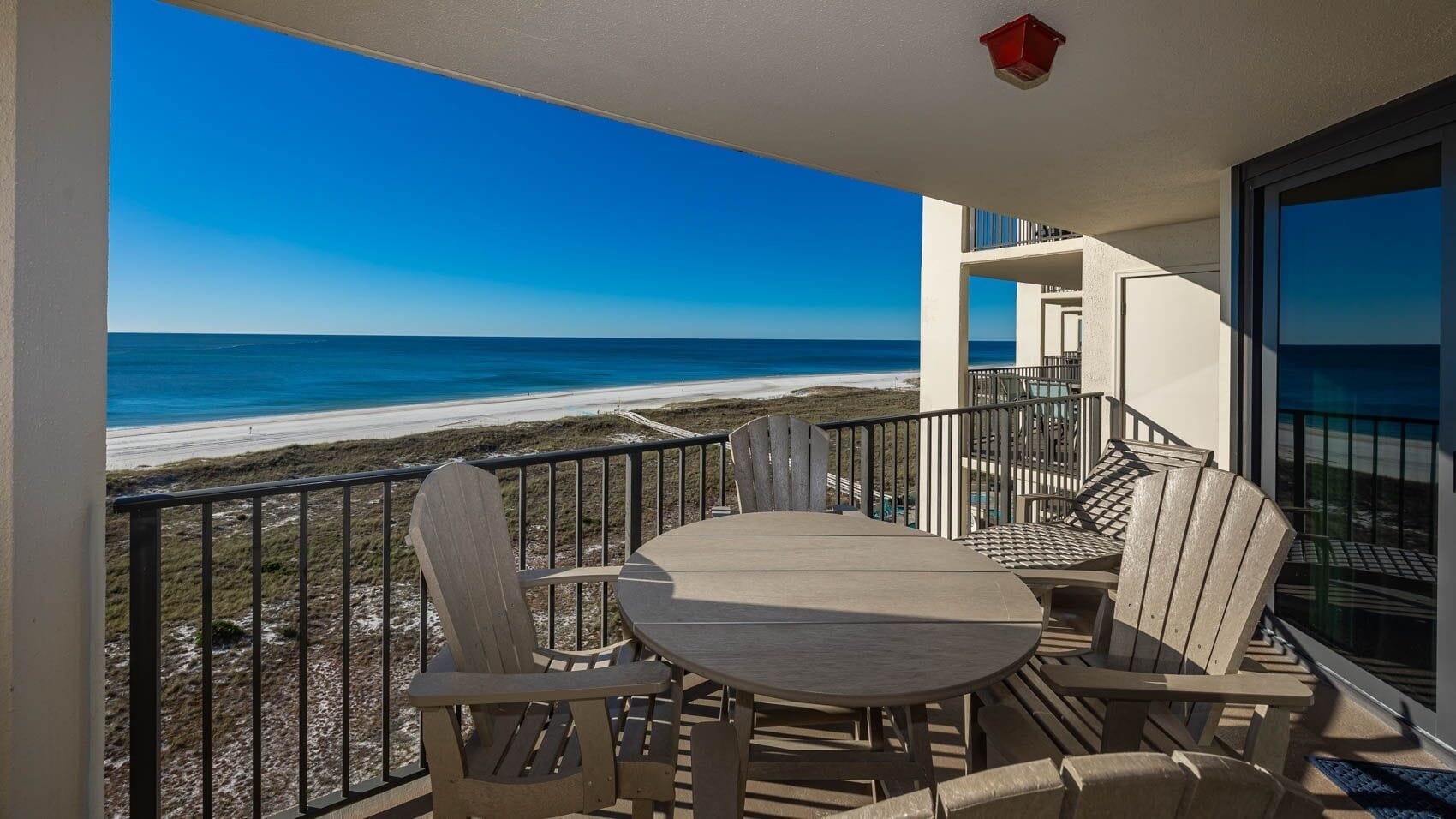 A balcony with a view of the beach and ocean.