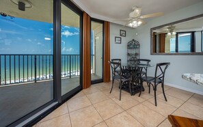 Ein Balkon mit Glastür, der in einen Essbereich mit Tisch und Stühlen führt.