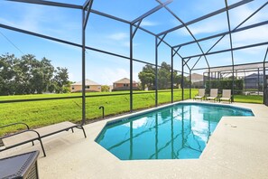 A swimming pool with a metal frame and a grassy area in the background. - 8BR Disney Villa | Pool, W/D, WiFi, Billiards (Kissimmee)