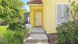 Um edifício amarelo com porta branca, número 8513, e uma janela com persianas.