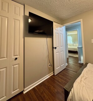 A bedroom with a bed, a closet, and a hallway leading to another room. - Central 5-Bed King Retreat with Hot Tub and Game Room (Indianapolis)
