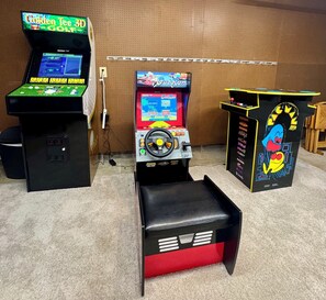 Three arcade machines in a room with a pegboard wall. - Central 5-Bed King Retreat with Hot Tub and Game Room (Indianapolis)