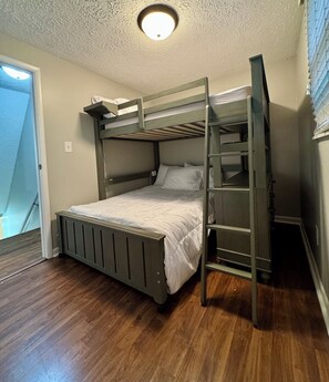 A bunk bed with a ladder, wooden flooring, and a ceiling light fixture. - Central 5-Bed King Retreat with Hot Tub and Game Room (Indianapolis)