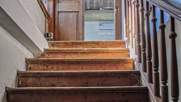 Eine Holztreppe mit Handlauf, die zu einer Tür führt.