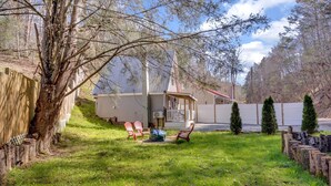 A house with a fenced yard, a covered porch, and a small shed. - Cozy Pigeon Forge Cabin Near Dollywood・Fire Pit (Pigeon Forge)