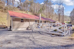 A small, single-story building with a red roof, a gated entrance, and a gravel driveway. - Pigeon Forge Single-Level Retreat Near Dollywood (Pigeon Forge)