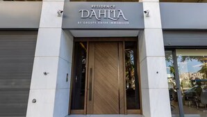Une entrée moderne d’immeuble avec une enseigne indiquant « Résidence DAHILA, par le Groupe AAFER IMMOBILIER ».