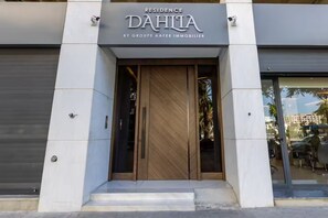 A modern building entrance with a sign for 'Residence DAHILA by Groupe AAFER IMMOBILIER.' - Elegant 3BR Apartment - Gym, Terrace & Nice View (Tanger)