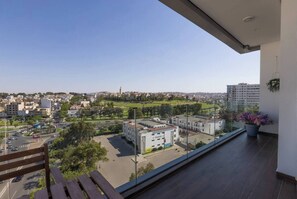 A balcony with a view of a cityscape, including buildings and a park. - Elegant 3BR Apartment - Gym, Terrace & Nice View (Tanger)
