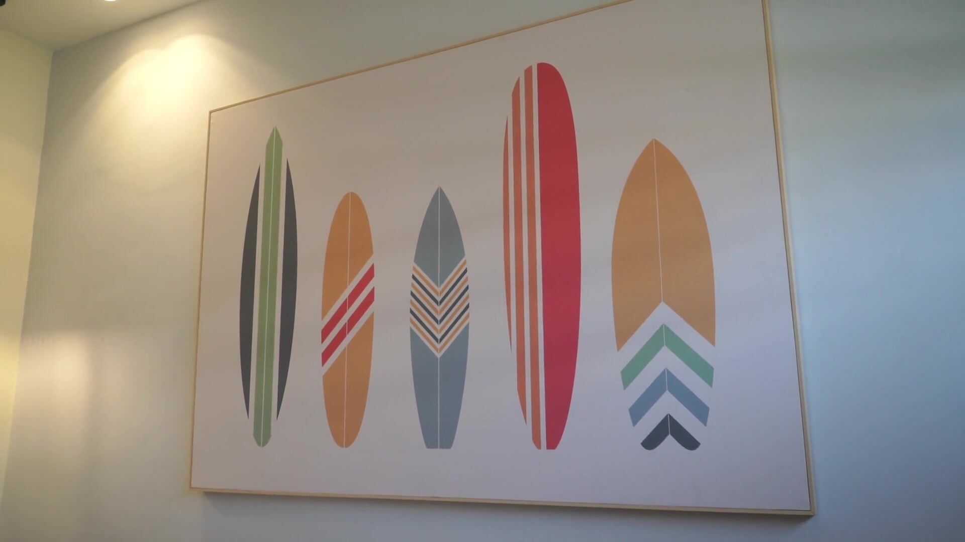 Una pared con varios diseños estilizados de tablas de surf.