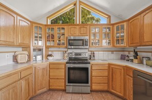A kitchen with wooden cabinets, a stainless steel oven, and a microwave.