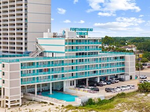 Un hôtel comprenant plusieurs étages, une piscine et un parking.
