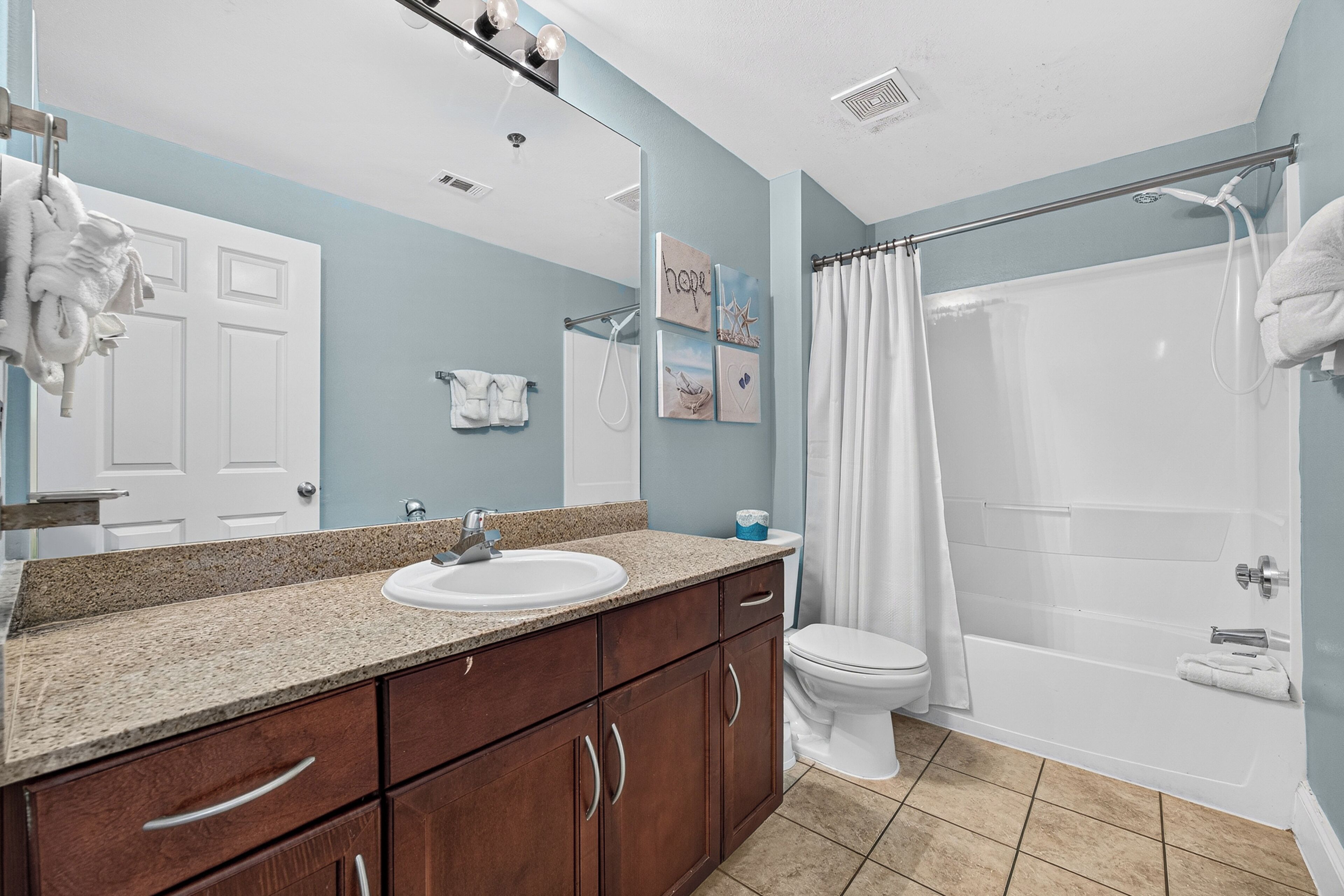 A bathroom with a sink, toilet, and shower.