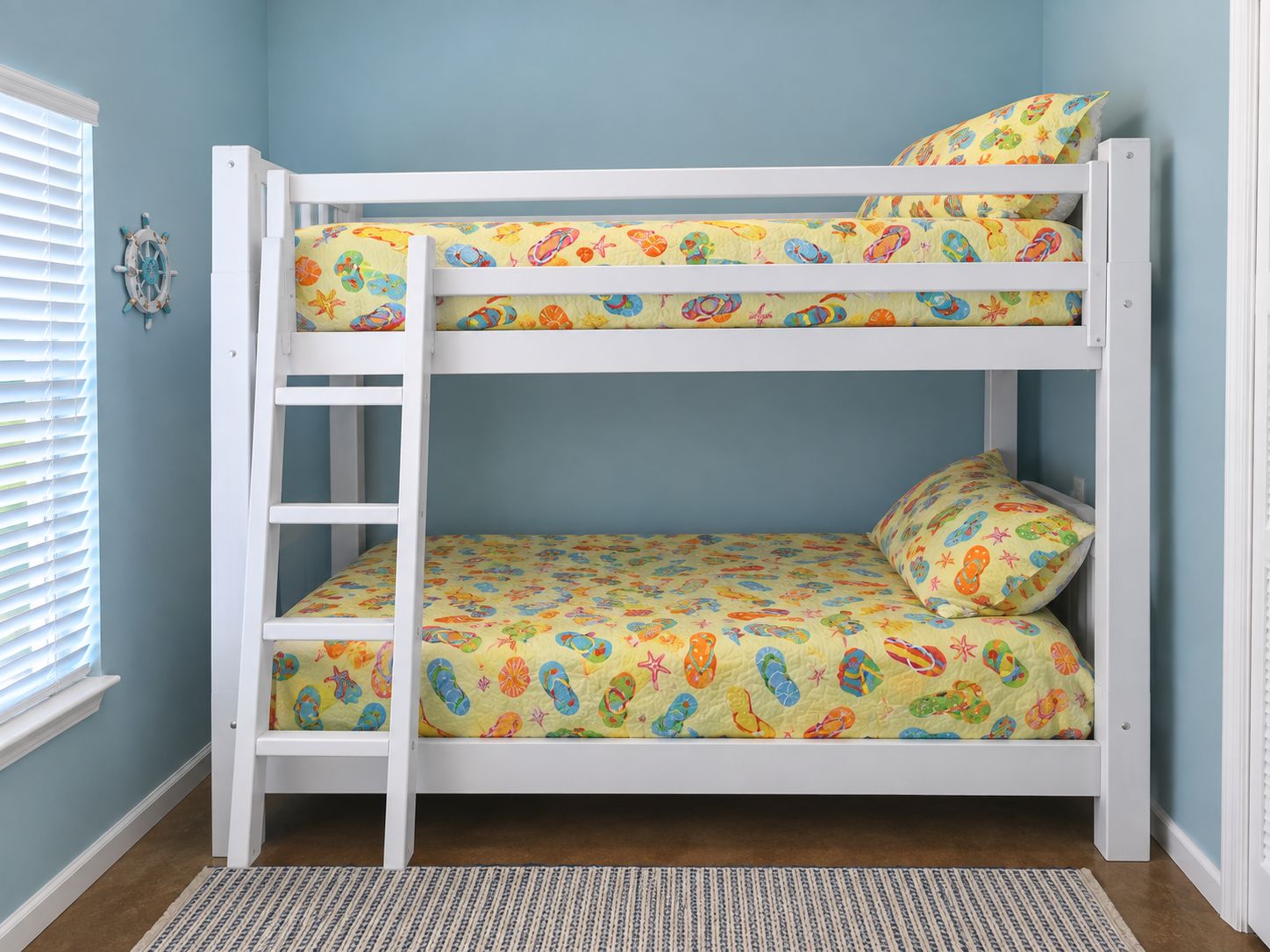 Een stapelbed met een ladder, een matras met een patroon en een kussen in hetzelfde ontwerp.